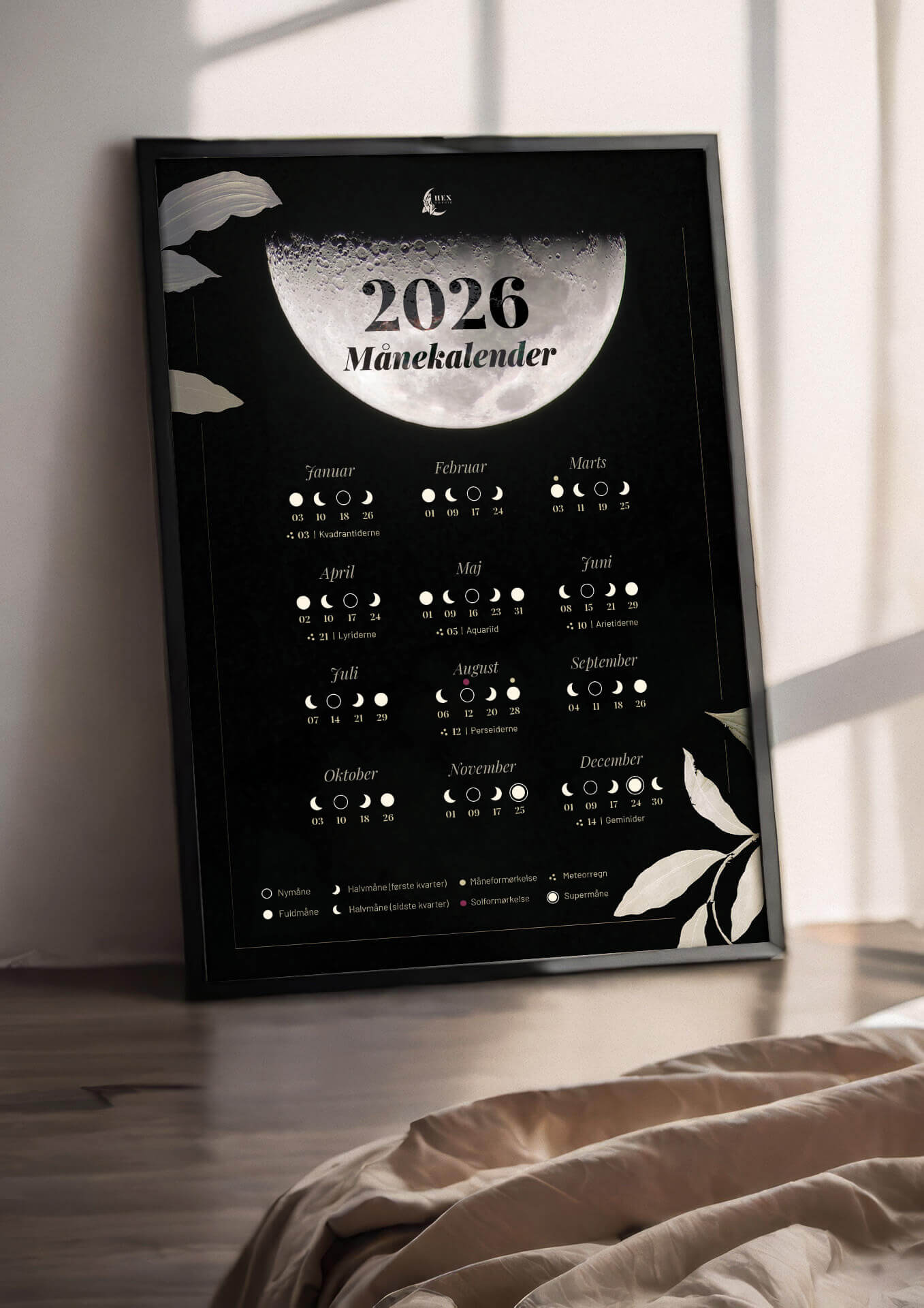 Månekalender 2026 plakat står i ramme på trægulv i en stue